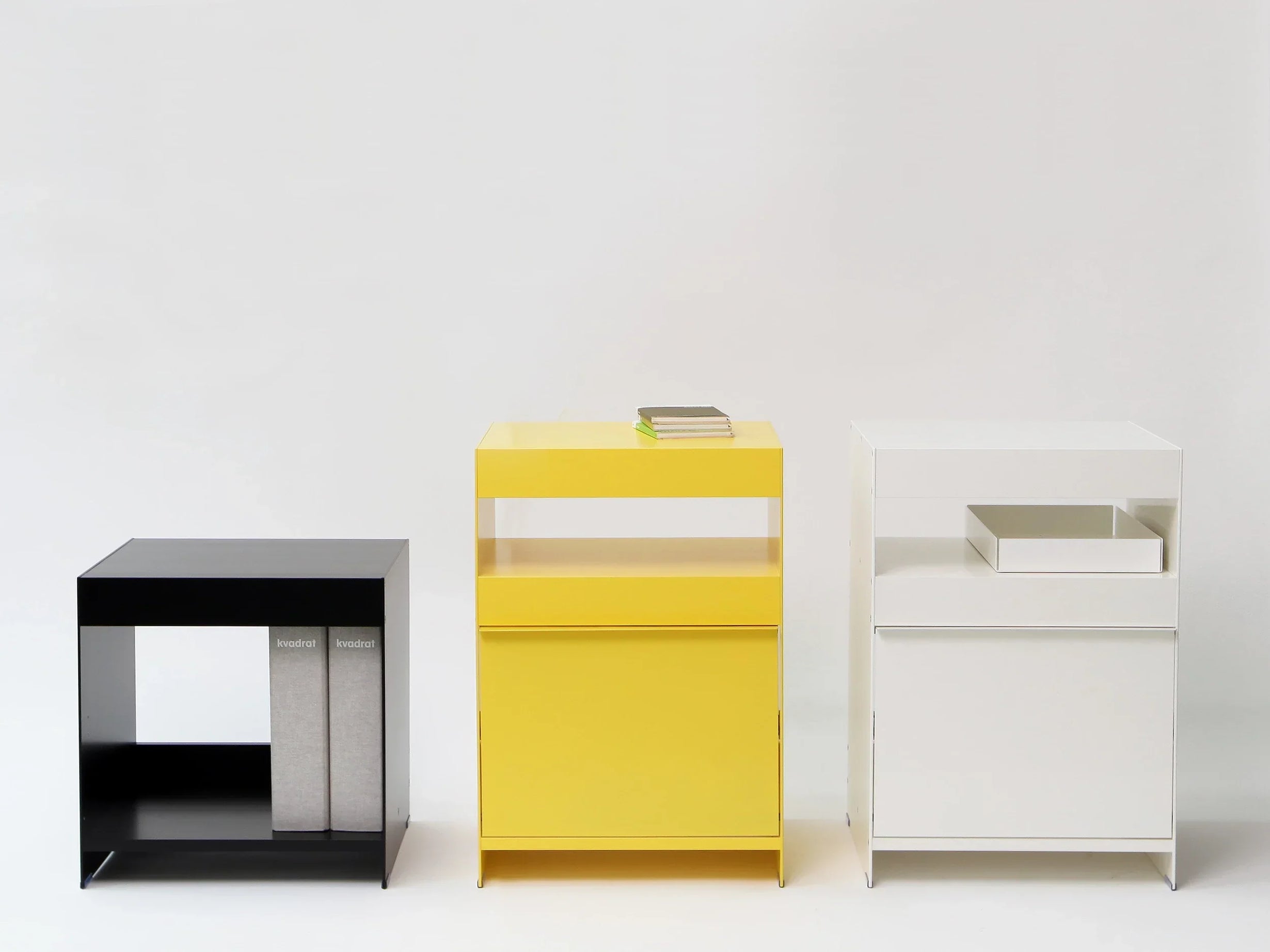 three aluminium modern side tables in a row, black, yellow and white