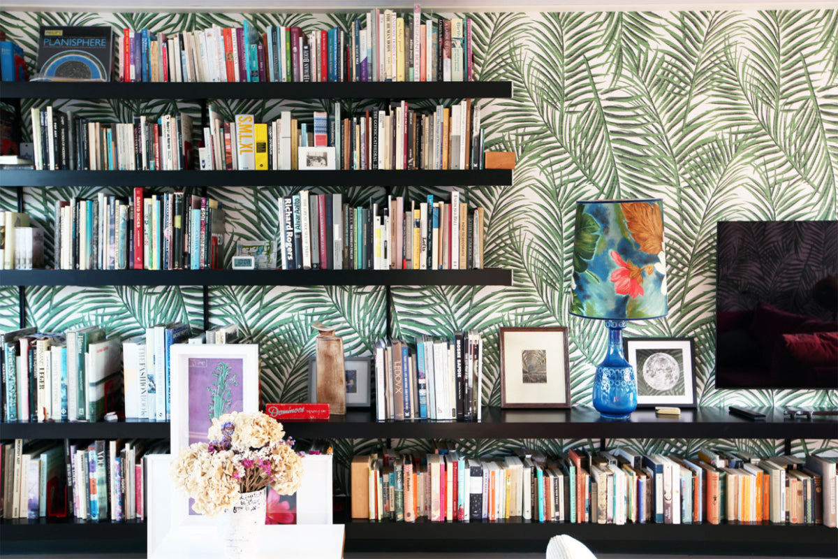 Black wall shelving system combined with bold wallpaper