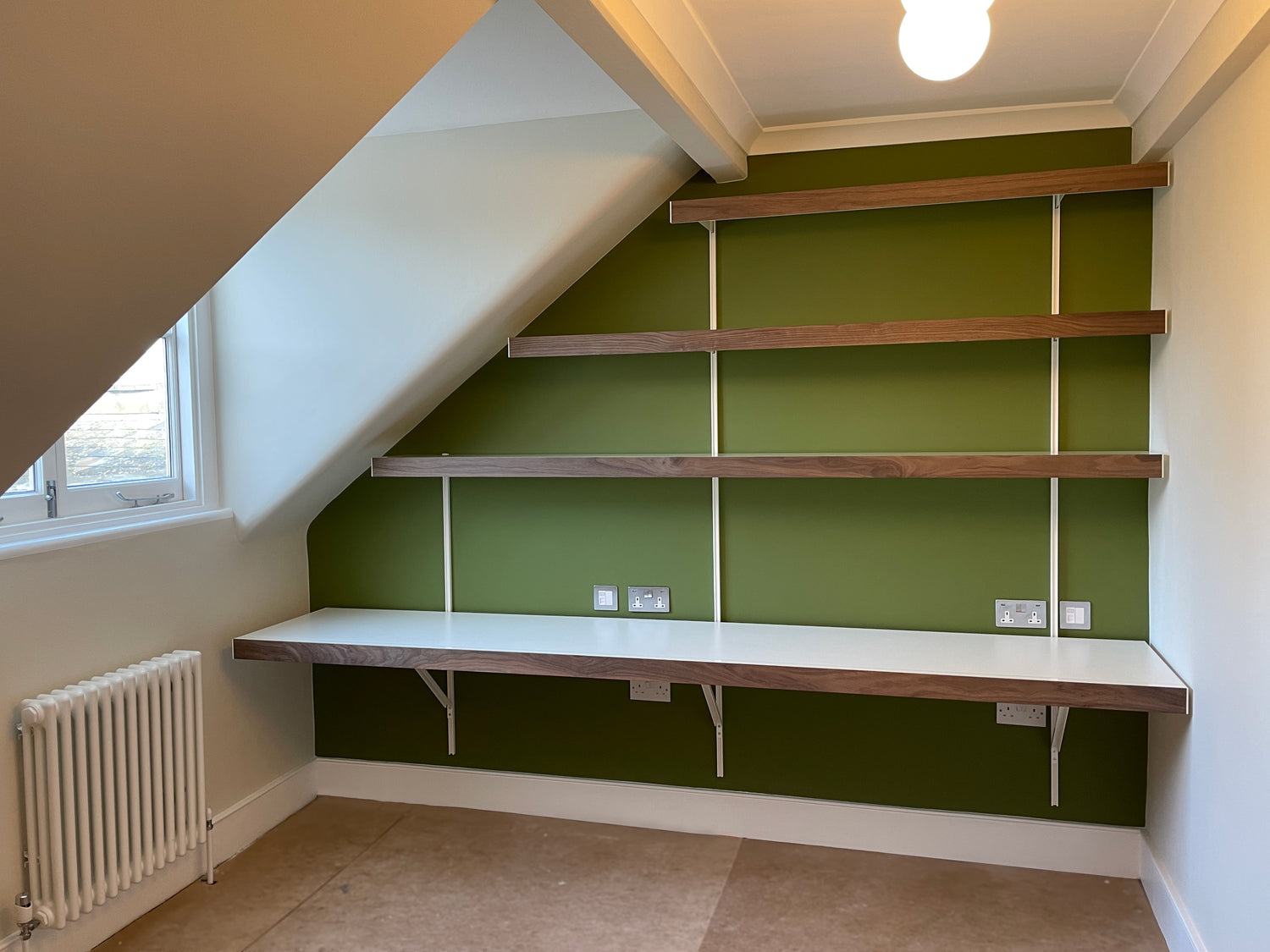 Long floating wall to wall desk and walnut floating shelves above