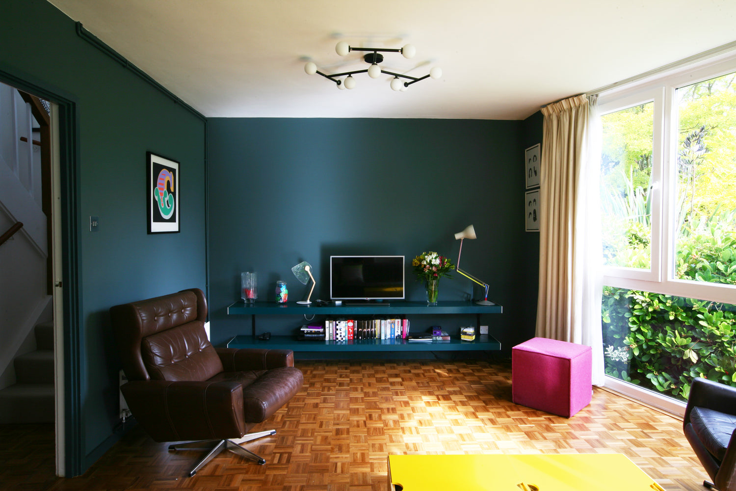 Wall mounted TV stand in modern span house on blue green wall