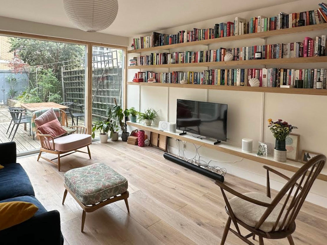 living room shelving system with long oak wall shelves for books