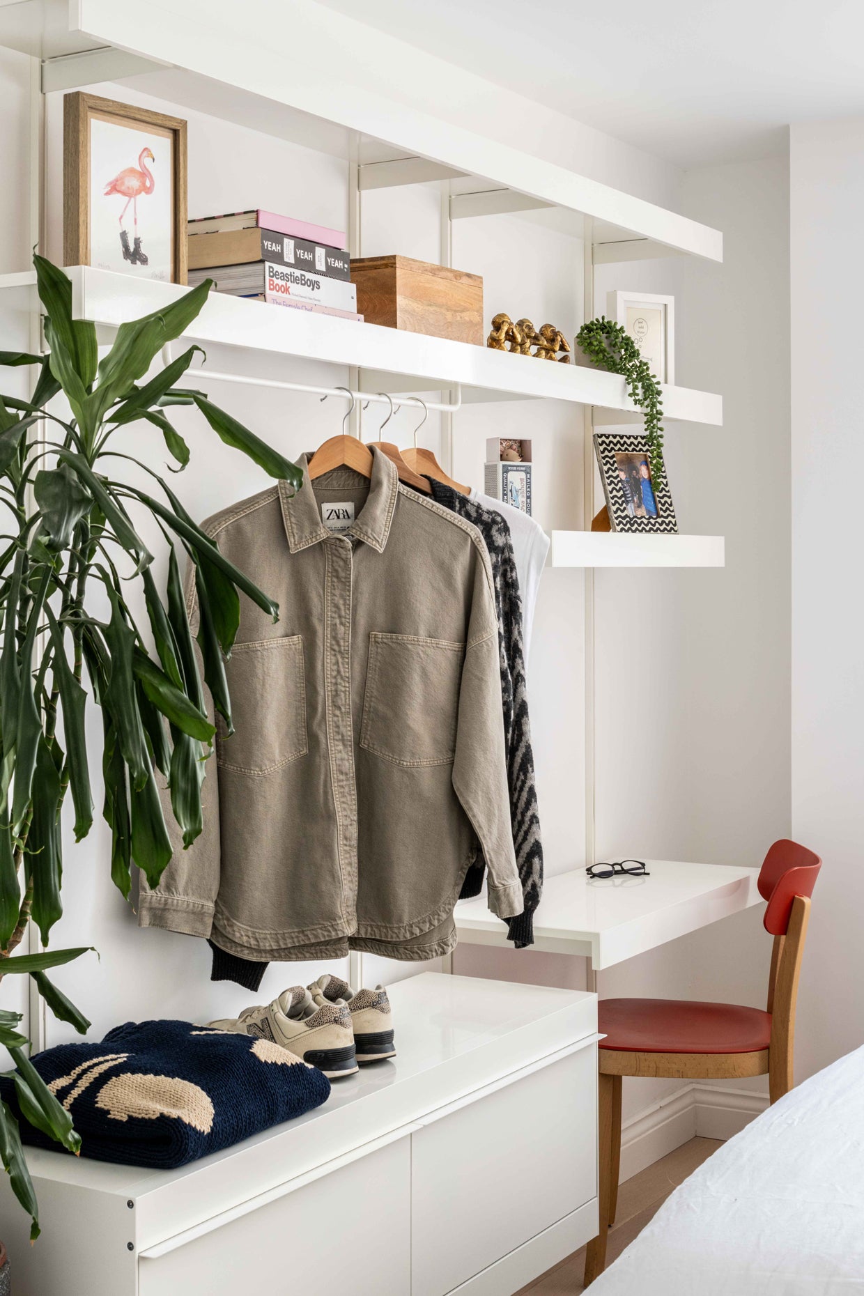 Open minimal aluminium wardrobe shelving system in bedroom