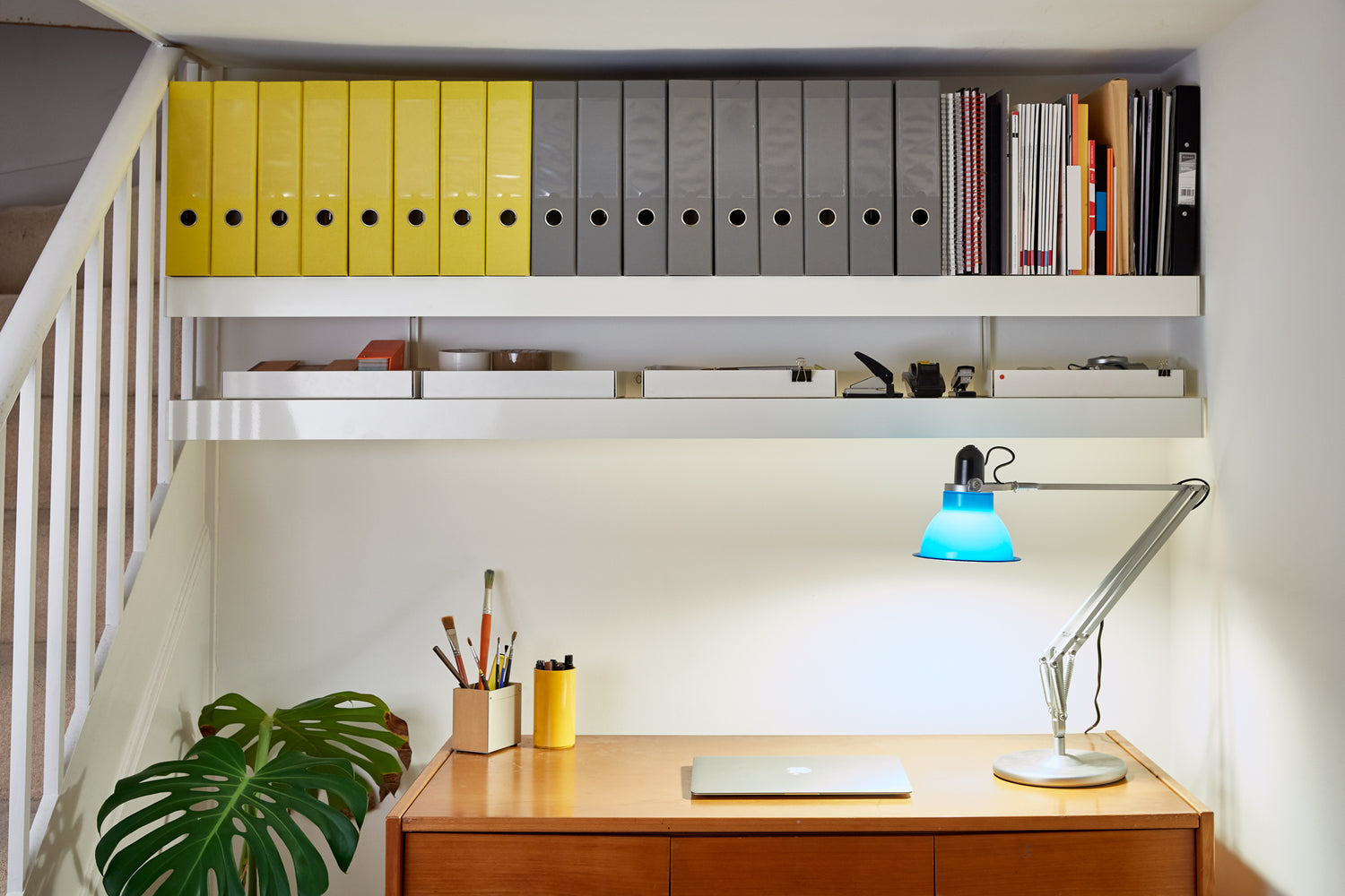 Strong office wall shelving with files above desk and lamp