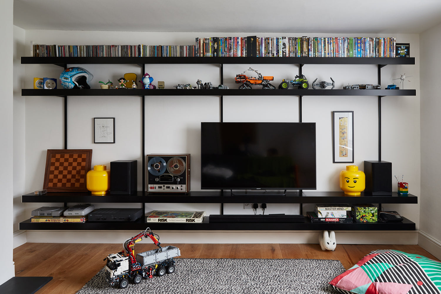 large wall mounted TV system with toys, board games and cd collection