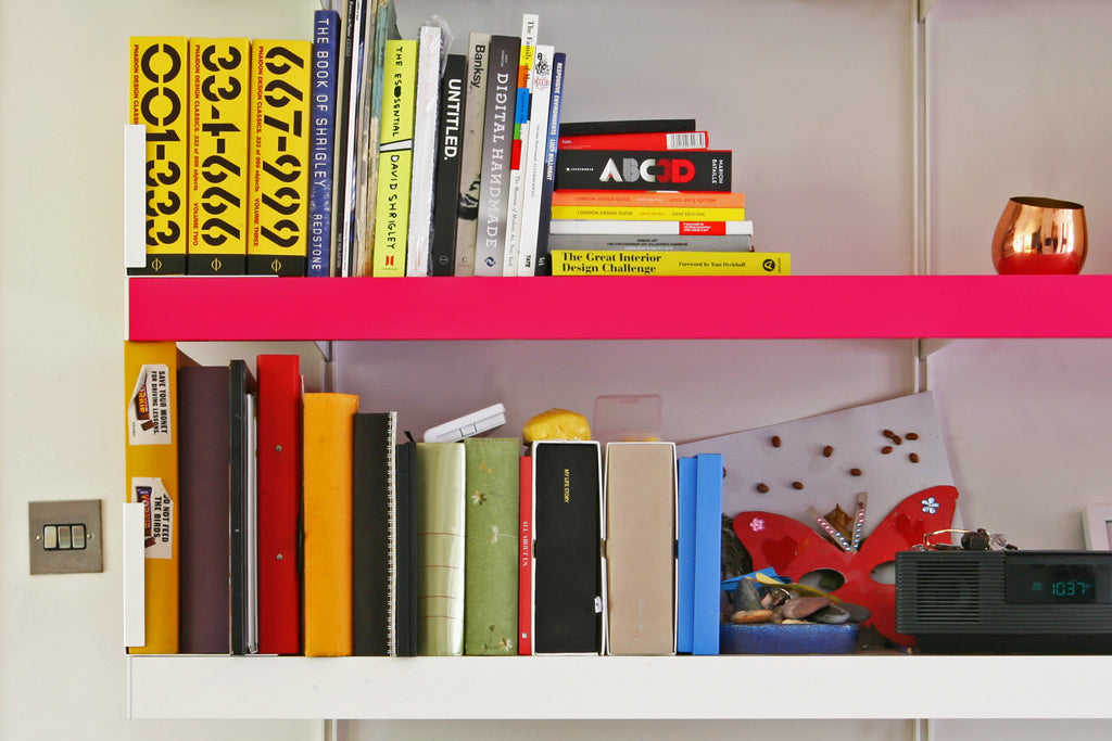 A bright pink bespoke shelf colour combined with a white shelving system