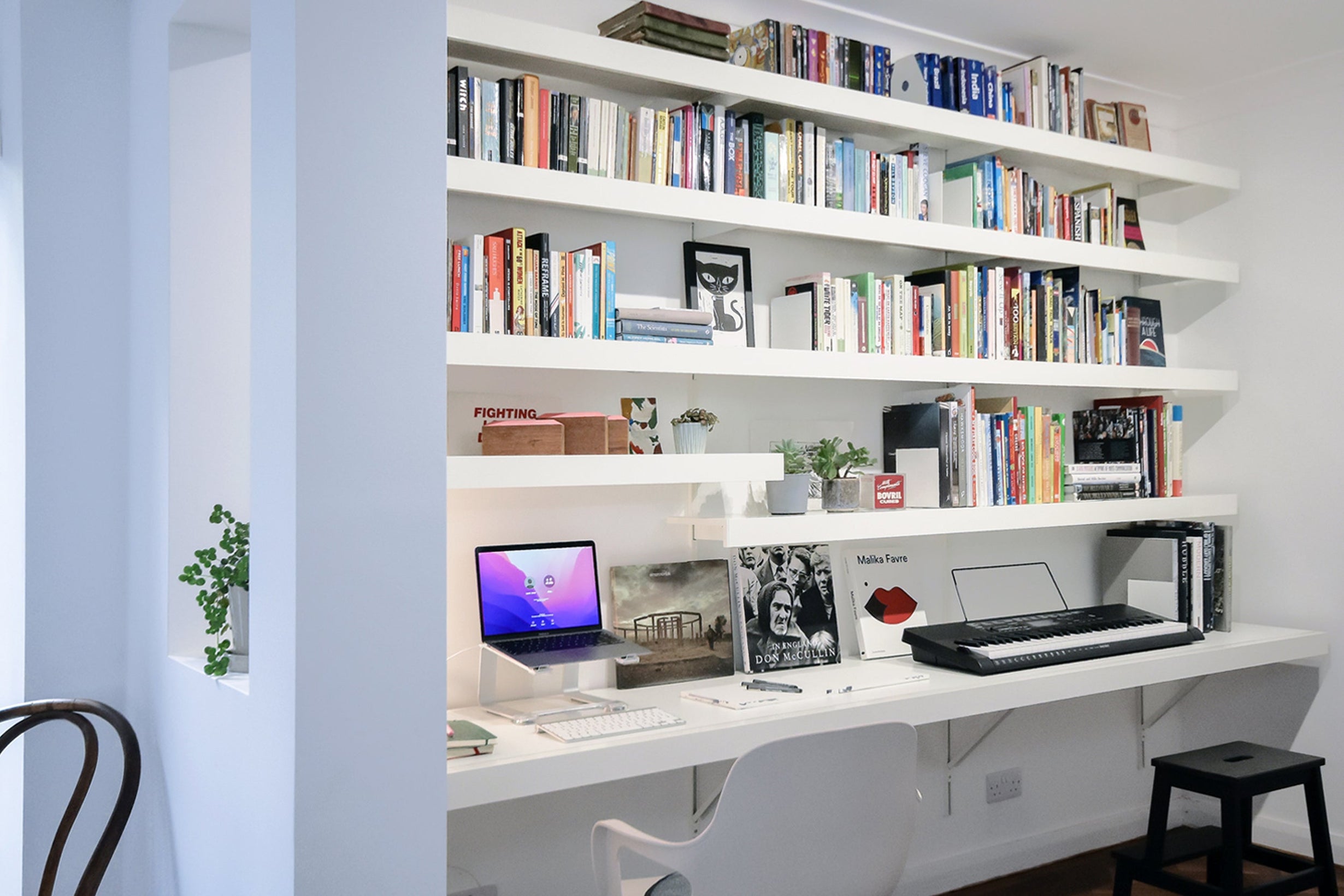 large home office with white wall desk with long shelving