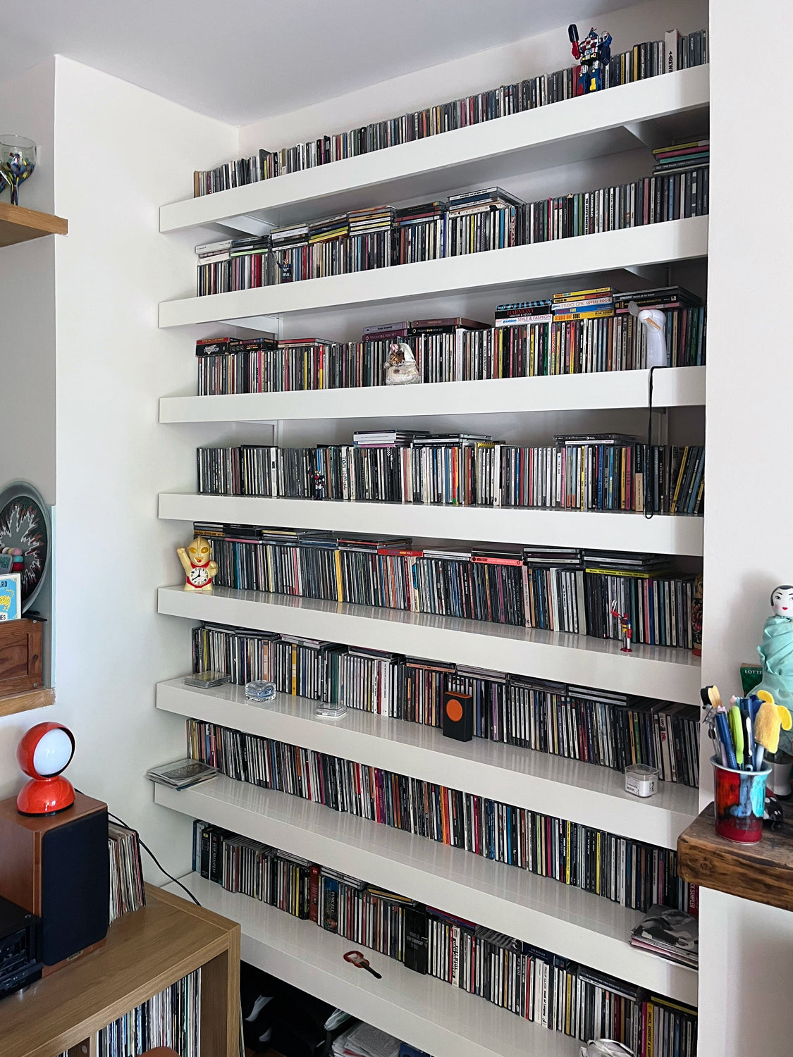 cd collection in alcove on white wall mounted shelving