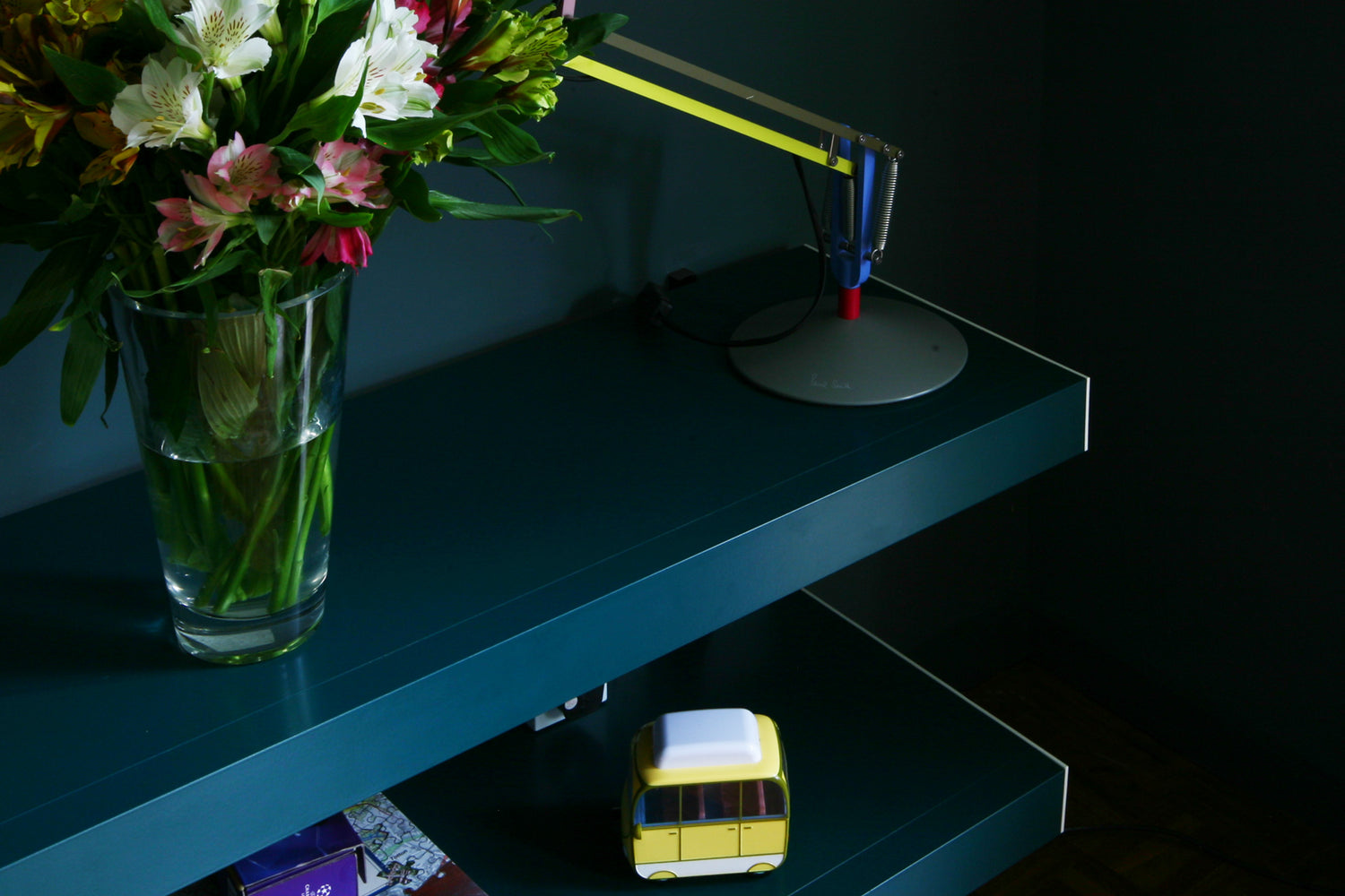 Blue green TV shelving detail with flowers and lamp