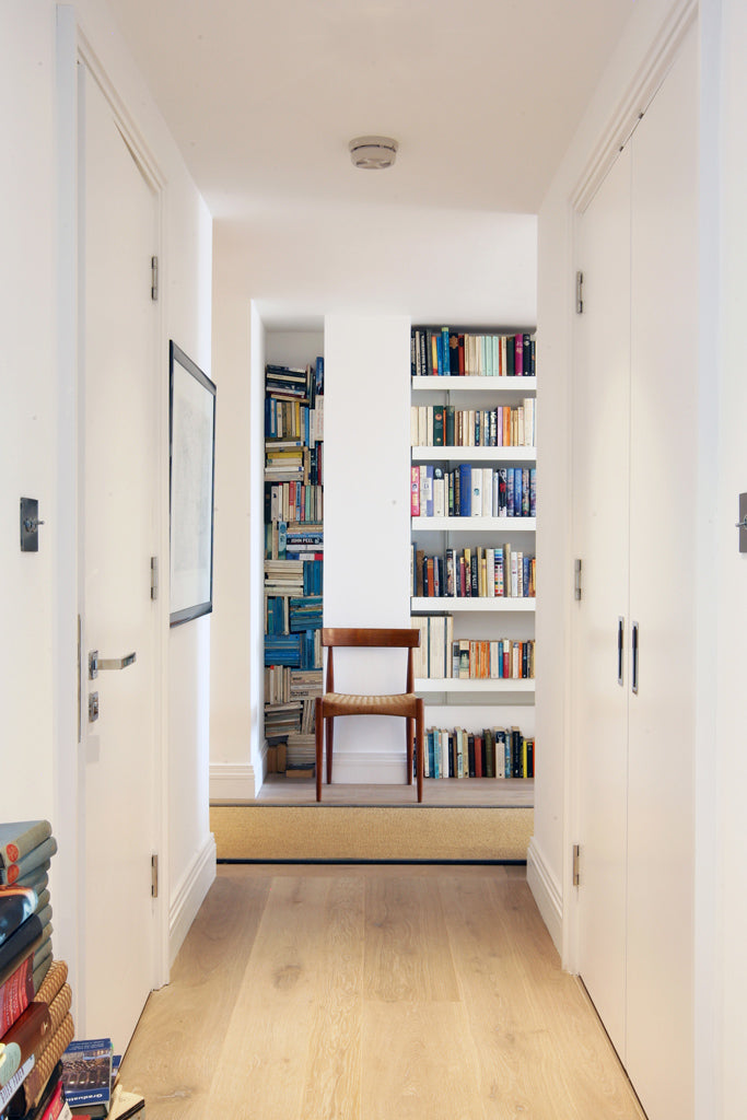 corridor with modern book shelving built in at end