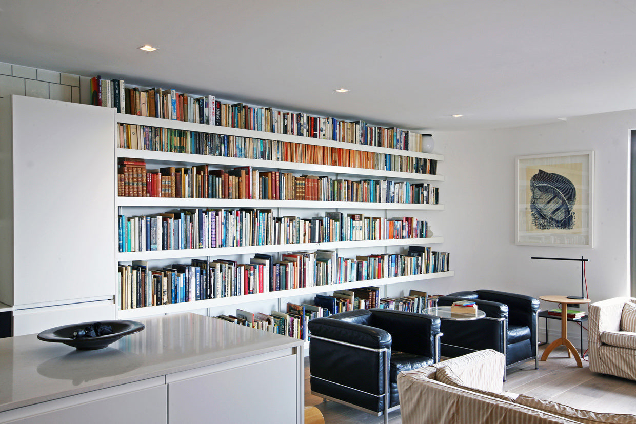 long white modern book shelving wall mounted in architects living room