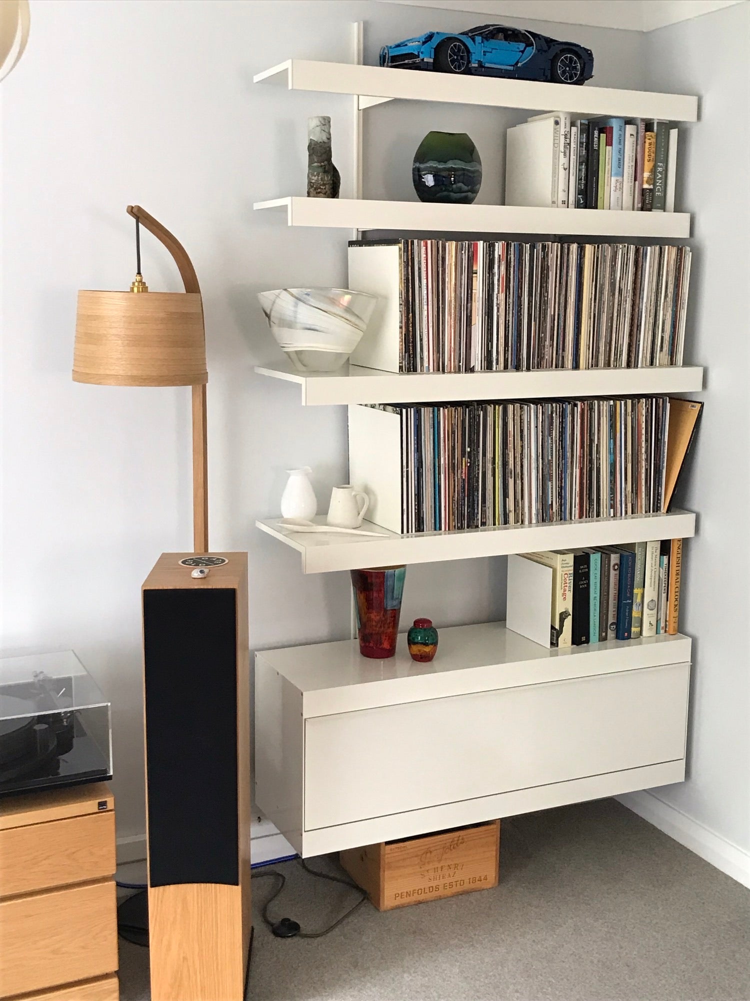 Vinyl collection wall mounted on shelving system with shelves and white cabinet