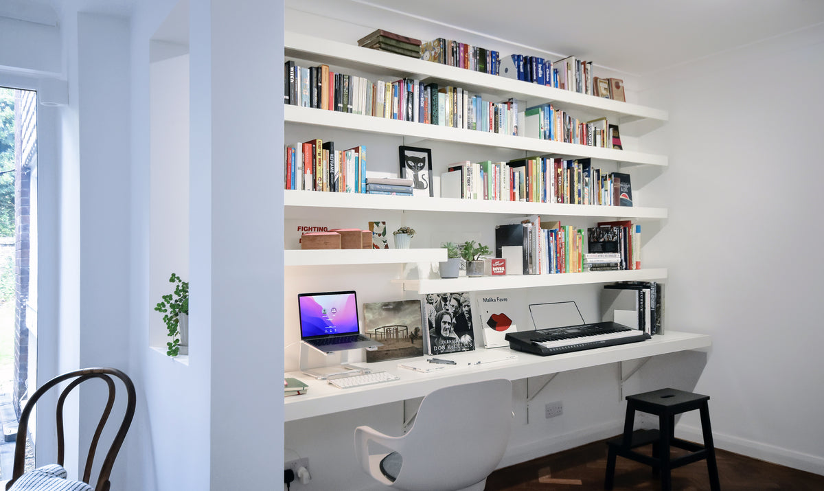 Modern white home office shelving system with large wall desk and floating shelves
