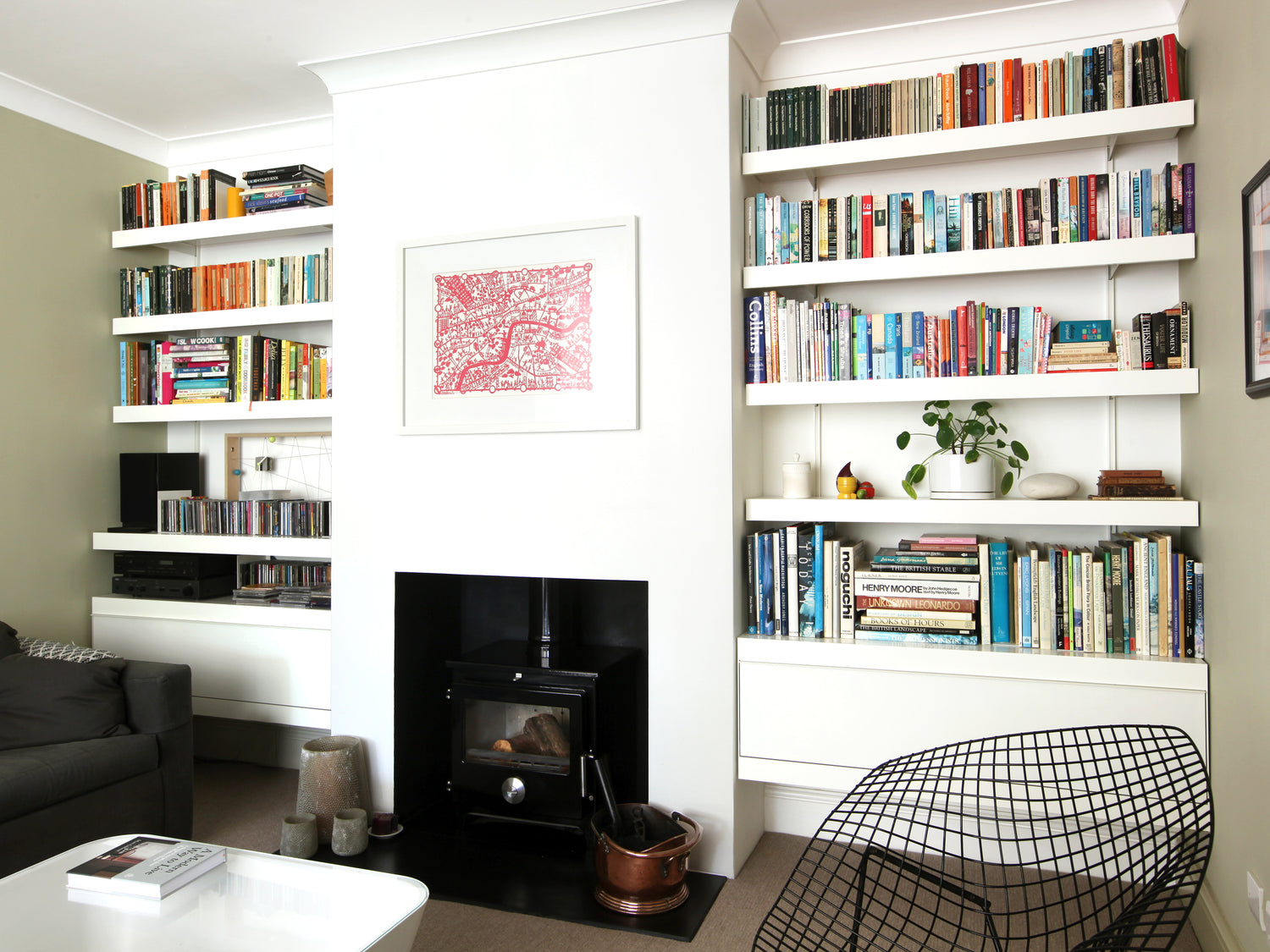 Modern alcove shelving with white wall mounted cabinets and floating shelves