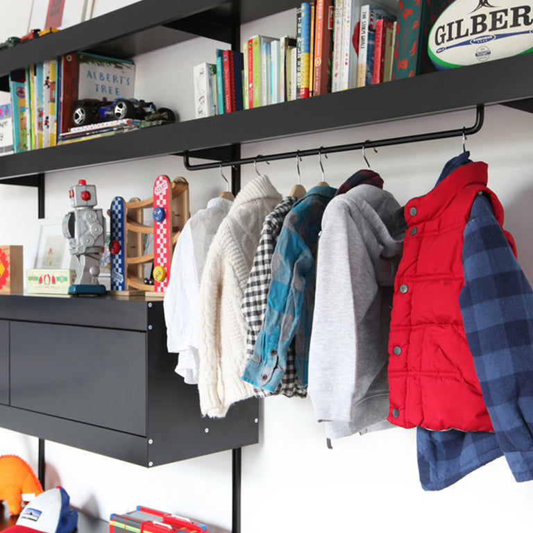 Black open wardrobe shelving system with toys and kids clothes and clothes hanger