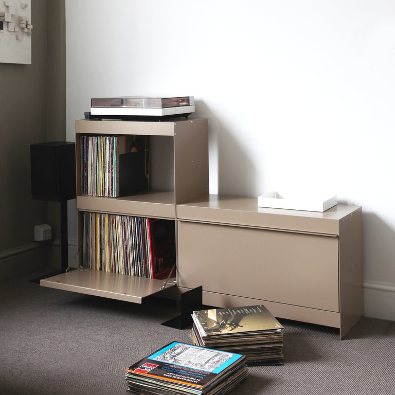 Beige entertainment console with records and a turntable in a room setting.