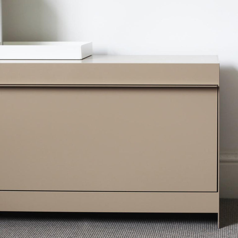 Beige TV cabinet with white tray against a neutral wall