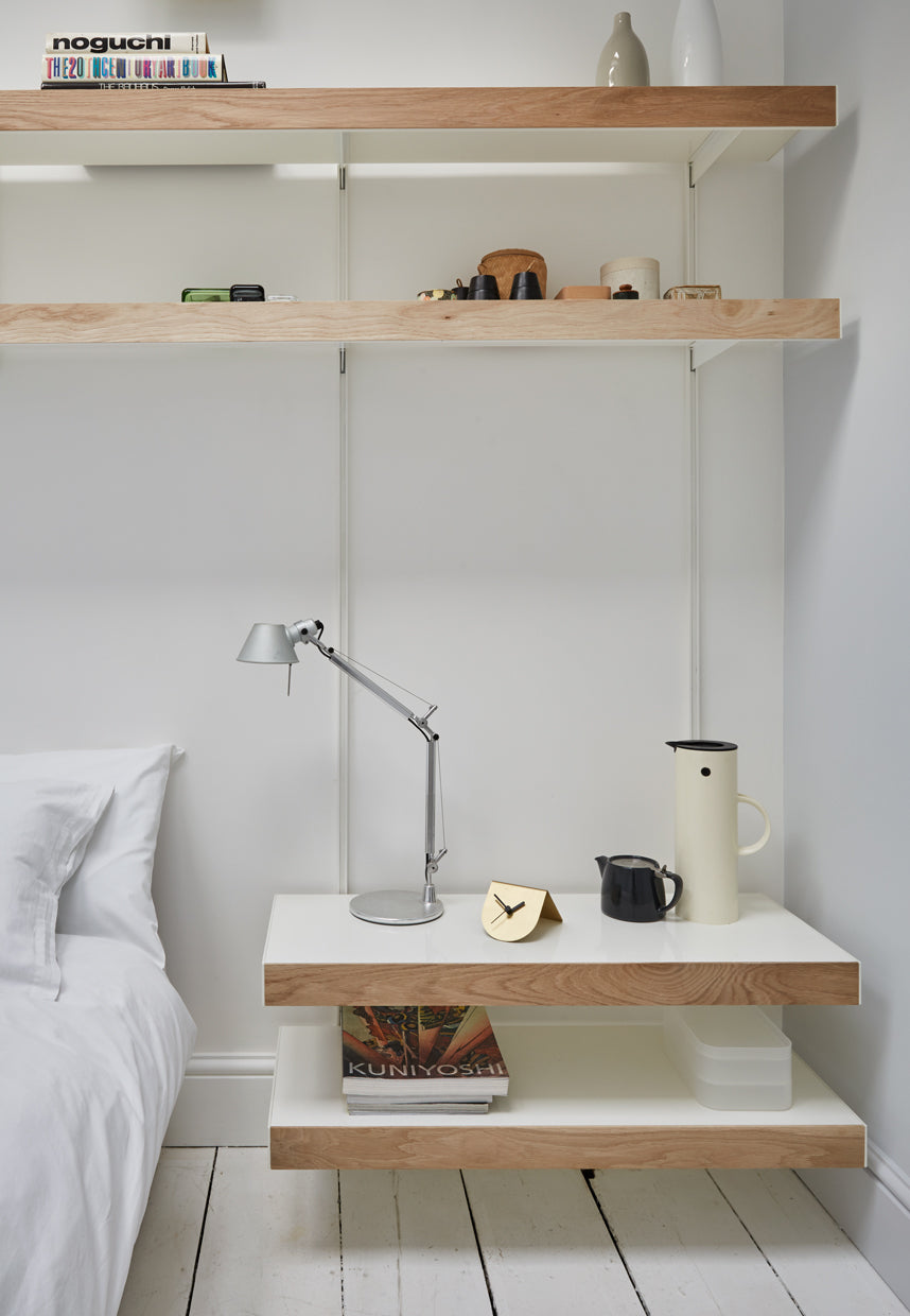 Oak shelving system over bed and bedside table