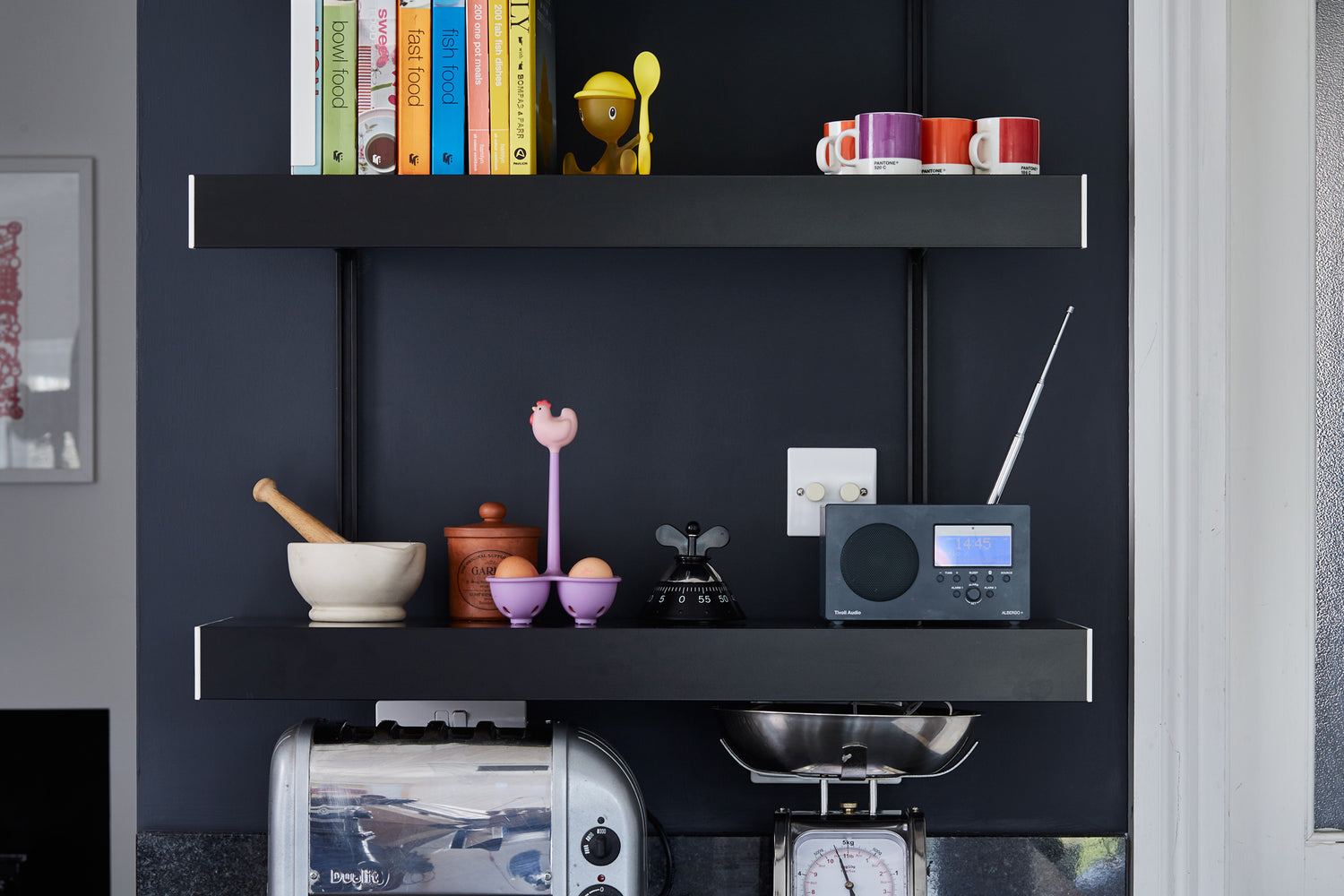 small black kitchen shelving system wall mounted on black wall