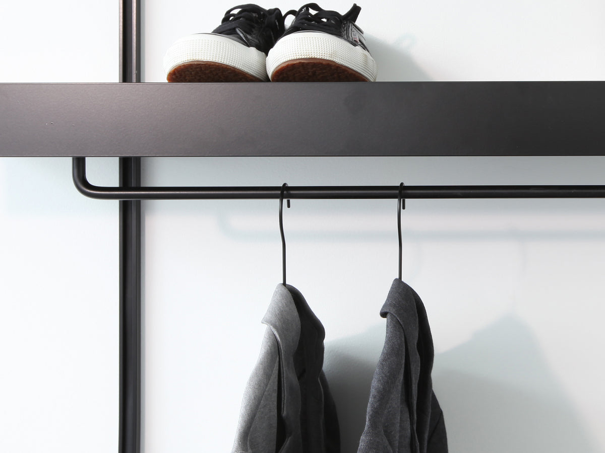 black wall shelves with modern black clothes rails