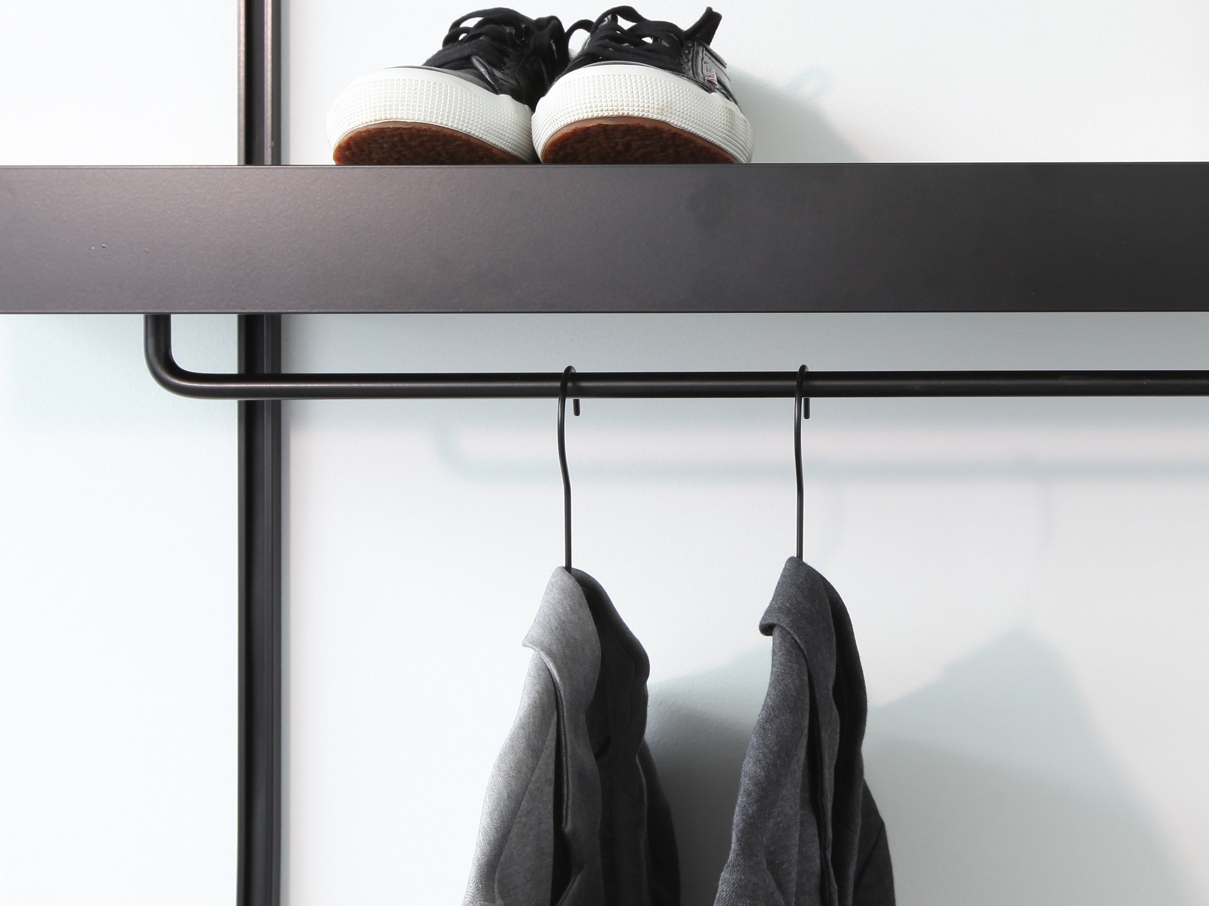 black wall shelves with modern black clothes rails